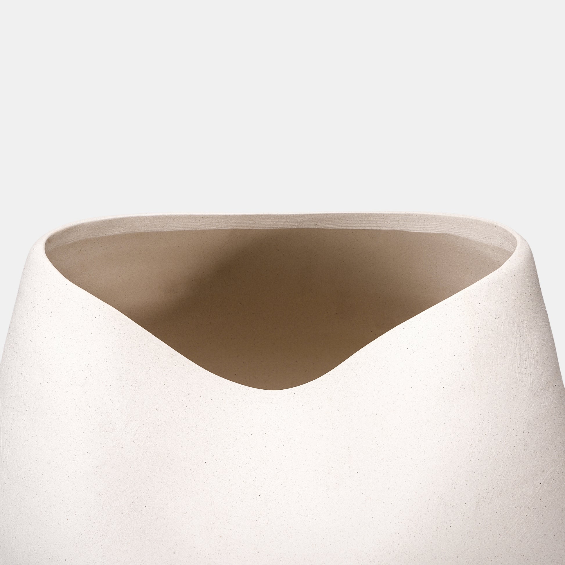 A sculptural large vase crafted with a sandy matte finish, perfect for coastal or farmhouse interiors. The white vase’s rounded silhouette holds sprawling flowers on vase arrangements, while petite bud vases add layered texture nearby. 
