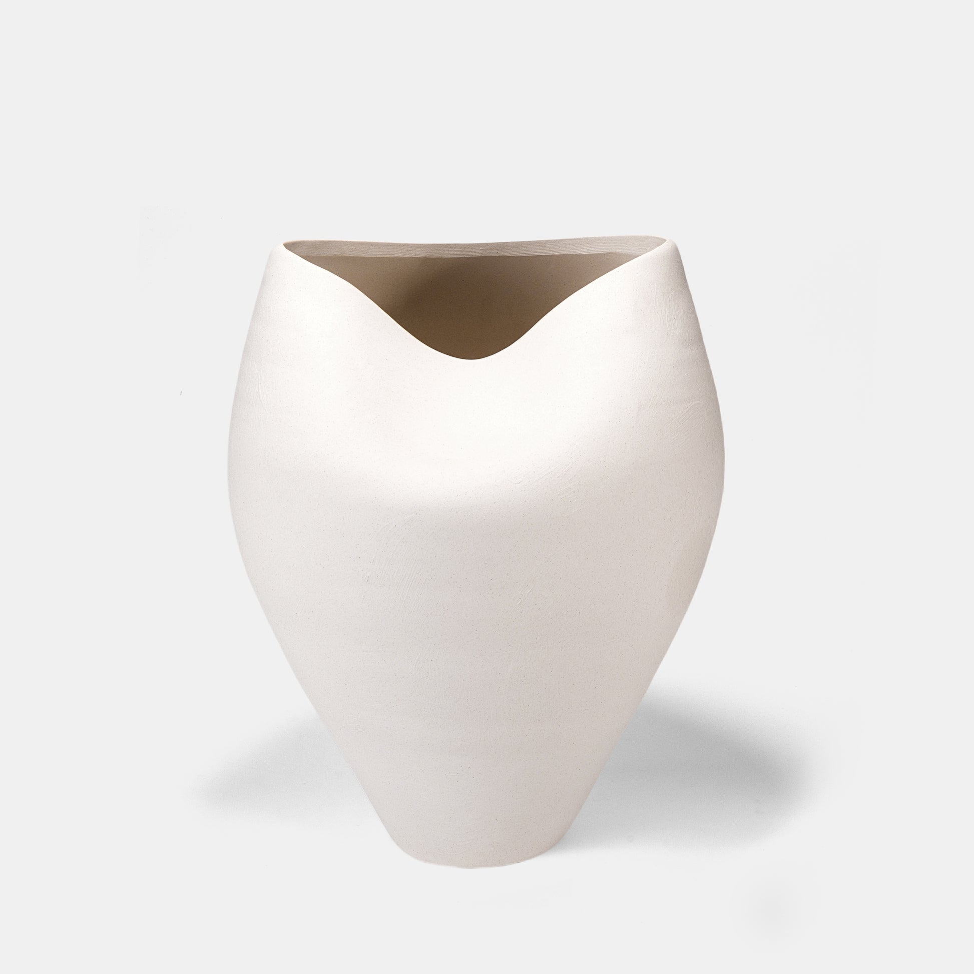 Merge art and function with this handcrafted large ceramic vase. The off-white color vase’s sandy texture and curved design enhance flowers on vase displays, while its floor vase stature anchors rooms. Complement with bud vases for depth. 
