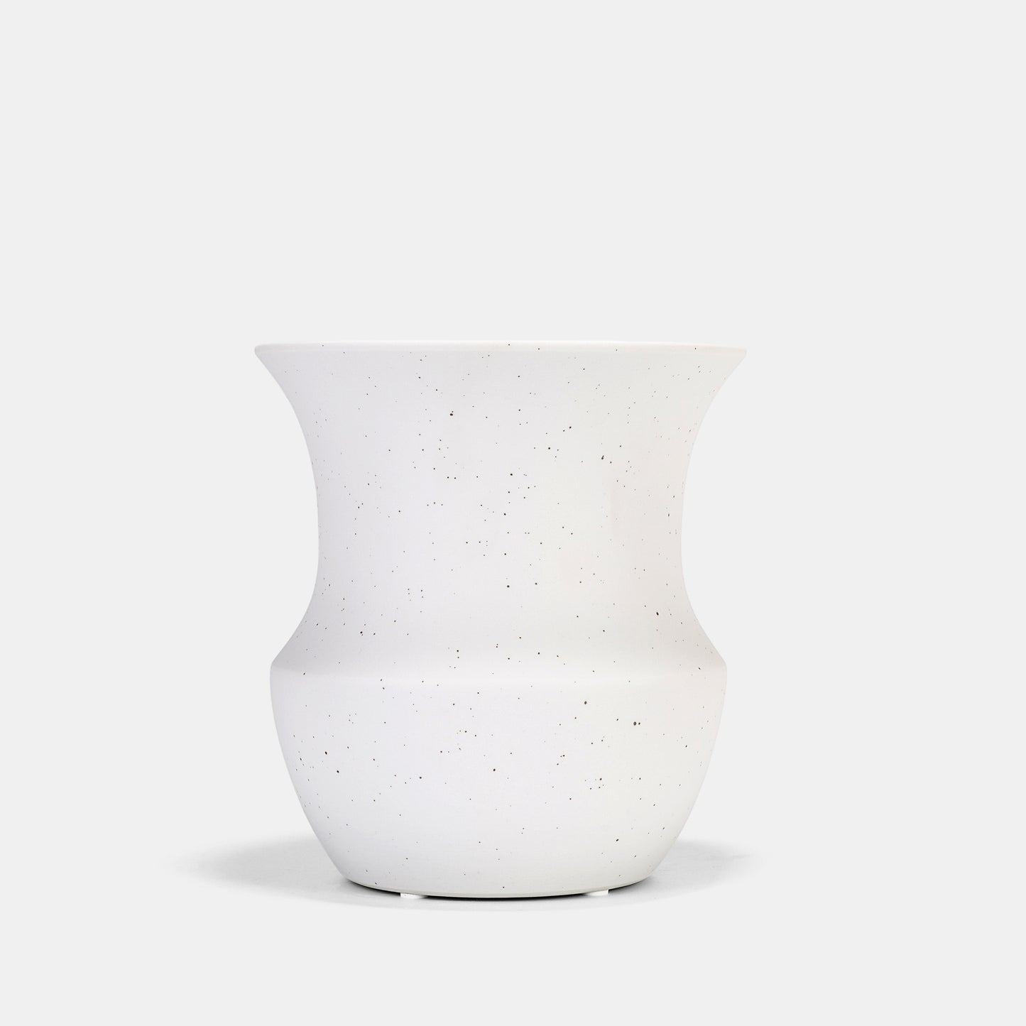 This ceramic vase’s matte white surface transitions from functional vessel to sculptural decor. Its speckled texture complements flowers on vase arrangements or dried grasses, while the neutral palette harmonizes with bud vases in eclectic tablescapes. 