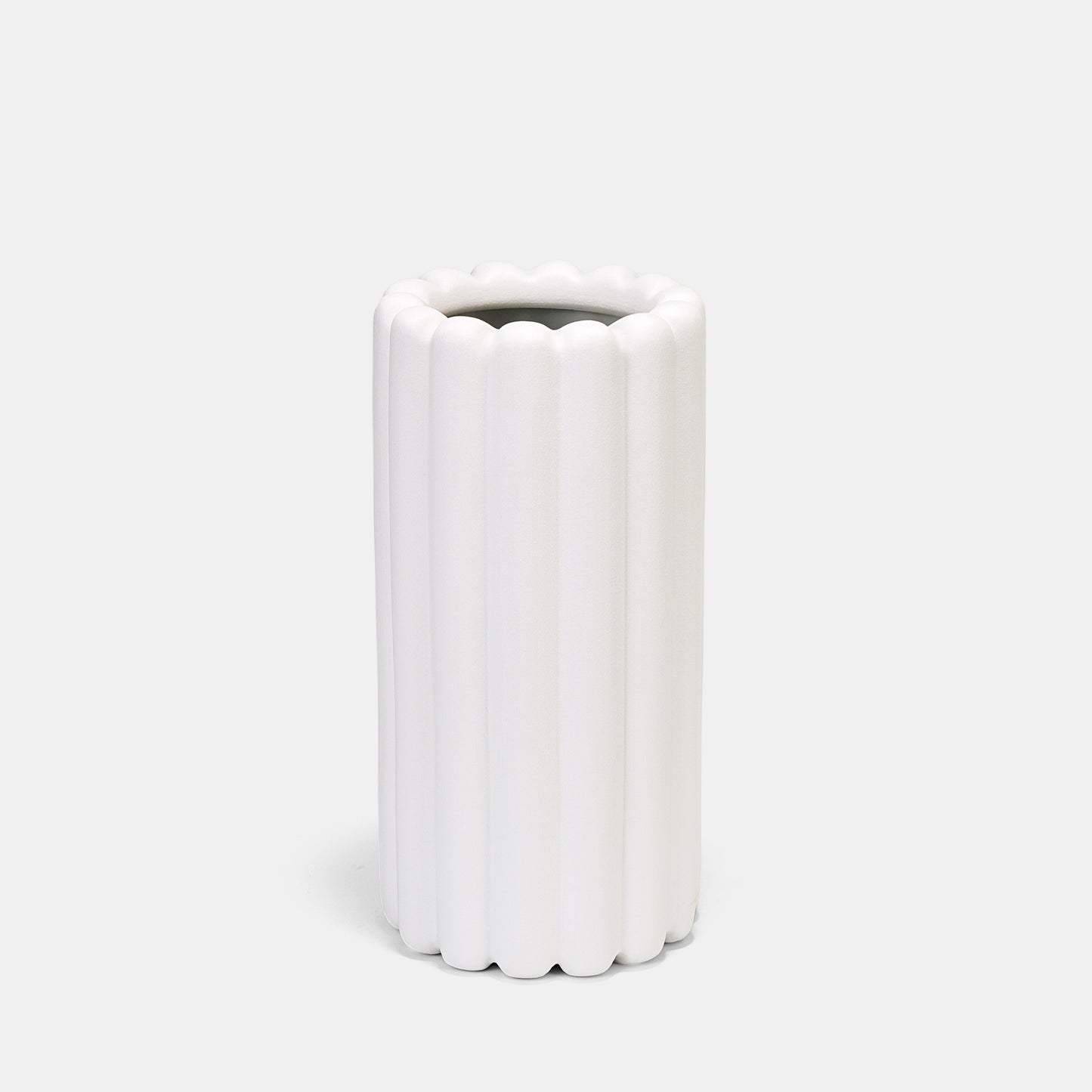 Crafted from heavyweight ceramic, this white vase merges function and art—use as a tall vase for floral arrangements or let its ribbed silhouette stand empty as architectural decor. The neutral white color vase adapts seamlessly to bud vases pairings or solo floor vase statements. 