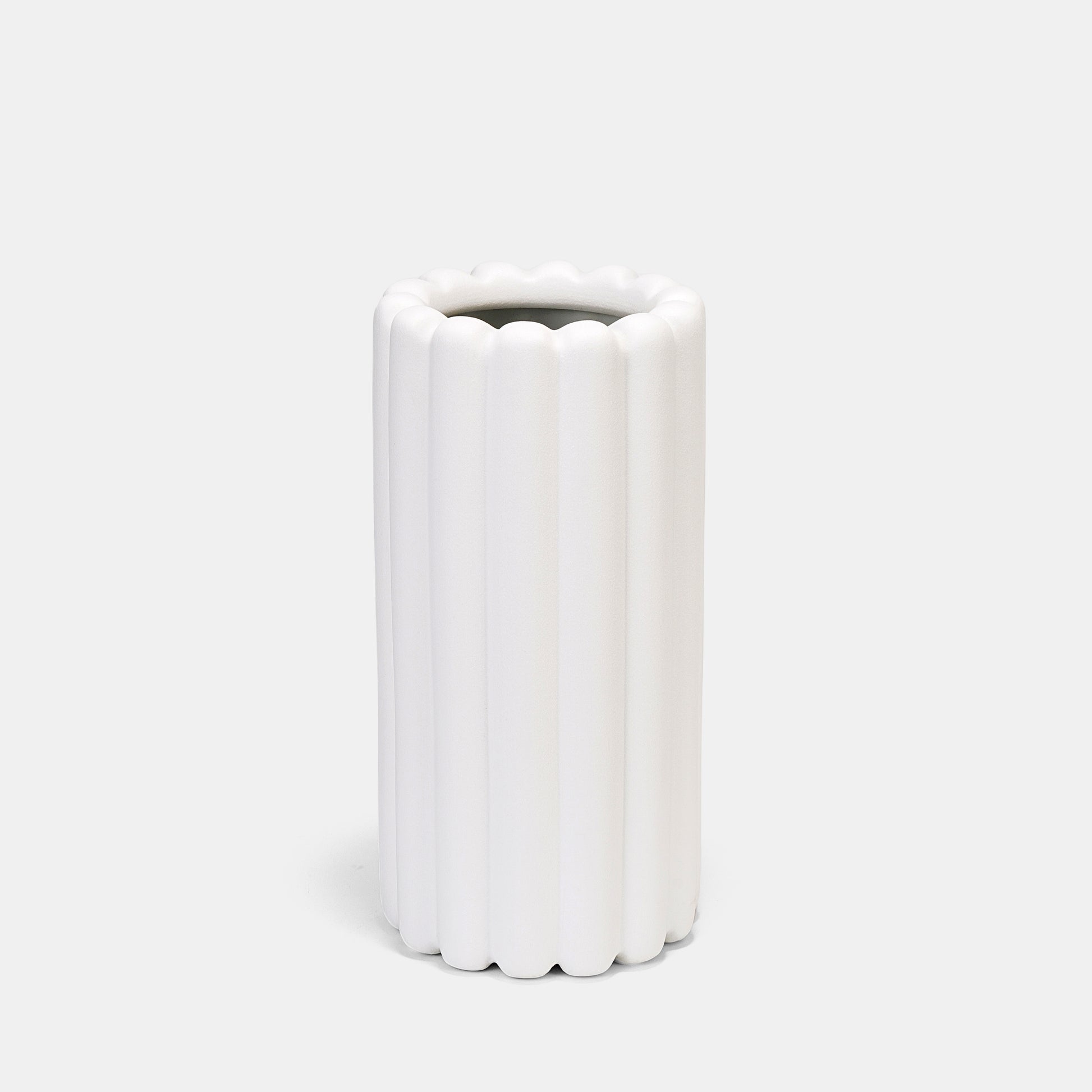 Crafted from heavyweight ceramic, this white vase merges function and art—use as a tall vase for floral arrangements or let its ribbed silhouette stand empty as architectural decor. The neutral white color vase adapts seamlessly to bud vases pairings or solo floor vase statements. 