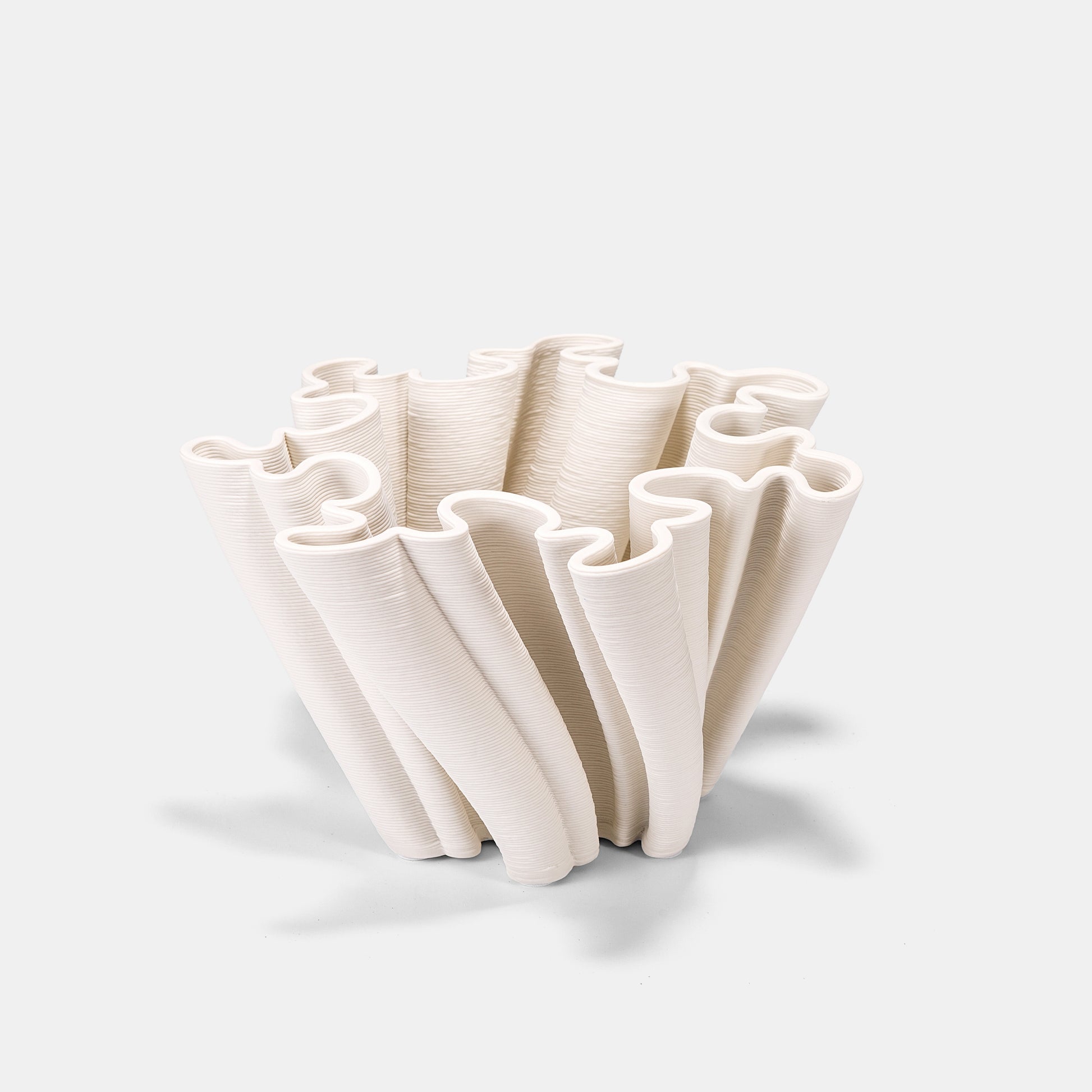Eco-conscious ceramic vase made from recycled clay. This white floral vase’s organic, asymmetrical form complements wildflower bouquets. The large white vase (20" tall) features a crackle-glaze finish, while its big white vase volume suits sprawling eucalyptus displays.